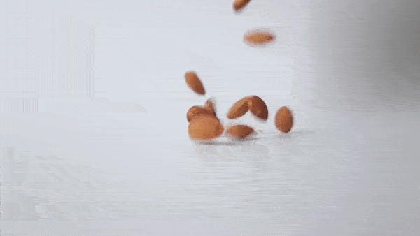 орехи миндаля падают на белый стол