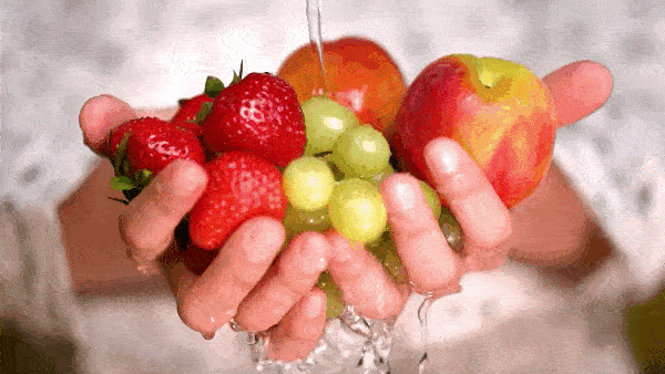 руки с фруктами под струёй воды